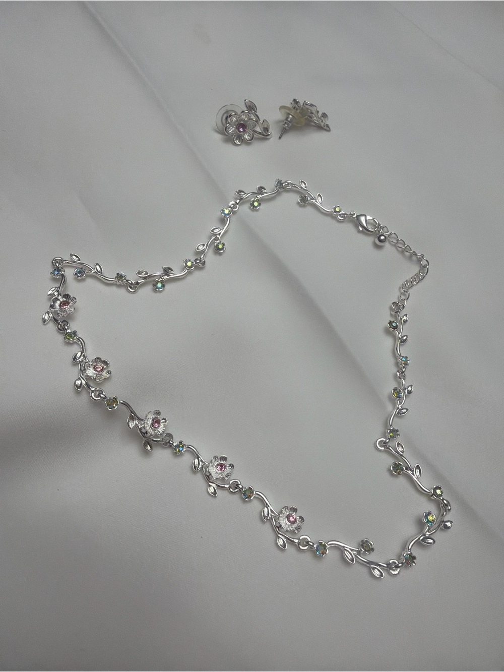 conjunto de joyería plateada con diseño de enredadera y flores adornadas con del